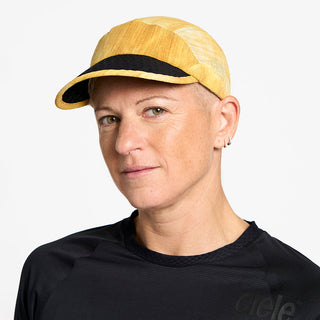 side view of ciele athletics FSTCap unisex running hat from the Elite collection in sphinx color, on a model