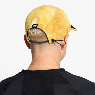back view of ciele athletics FSTCap unisex running hat from the Elite collection in sphinx color, on a model