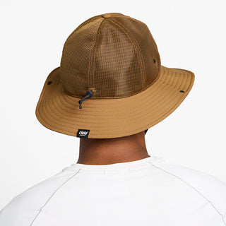 back view of the ciele athletics TRLBucket unisex running bucket hat in dark ochre color, on a model