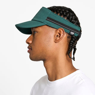 side view of the ciele athletics TRLCap unisex running visor with a curved brim in emerald color, on a model