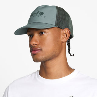 side view of the ciele athletics TRLCap unisex running hat with a curved brim in silver pine color, on a model